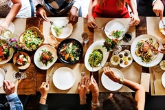 Image people seated at tables serving food