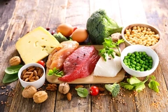 cheese, meat, beans and seeds on wooden background