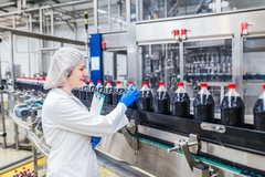 Image Woman operates bottling line.