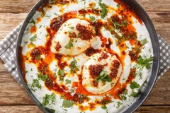bowl of white soup with dough balls on wooden background