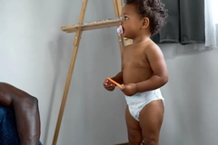 Toddler with a diaper and pacifier