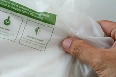 A person holding a biodegradable plastic bag.