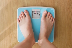 Image woman measures weight on scale