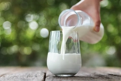 Image A hand pouring milk into a glass.