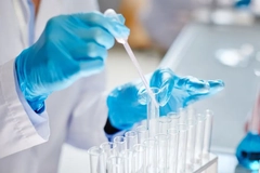 Image A person pouring liquid into test tubes