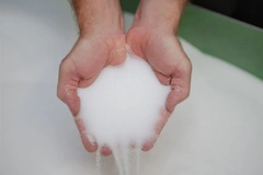 Image A close-up of hands holding tiny white beads