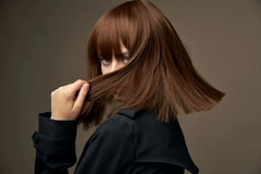 Image A woman looking at the camera through her hair.