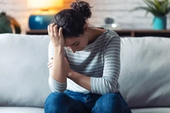 Image Depressed young woman sitting on a sofa