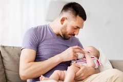 Image Man feeding baby infant formula