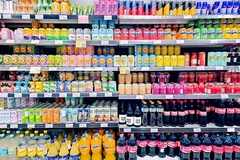 Image Cans and bottles of sodas on the shelf in the supermarket.