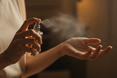 Person spraying fragrance.