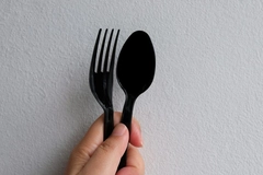 Image Holding plastic cutlery in hand.