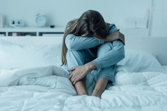 Image anxious girl sitting on bed