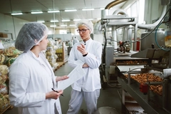 two female scientists talking in food factory