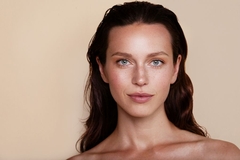 Image young woman looks into camera with neutral expression