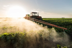 Tractor fertilizing field.