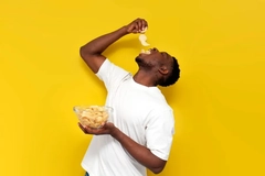 Image young man eating healthy chips