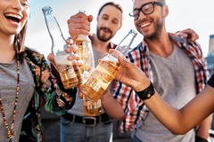 Young consumers drinking alcohol-free beer at party.