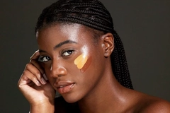 Image A Black woman with three foundation swatches on her cheek.