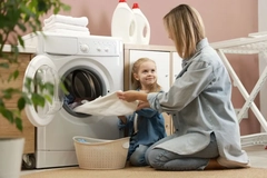 Image A mother and her child doing laundry together.