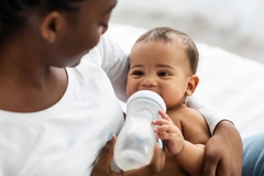 Image mother feeding baby with infant formula