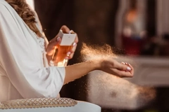 Image Perfume being sprayed on a woman's wrist.