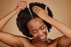Image Woman applies hair serum to hair roots