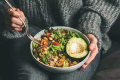 woman eating salad from a bowl