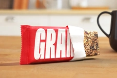 A red and white packaging for a food bar with white text