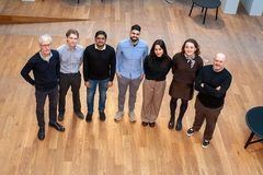 group of people on wooden floor group of people standing on wooden floor looking up
