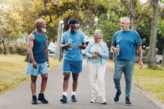 Image senior man and woman speak with two young men, wearing sports outfit in park