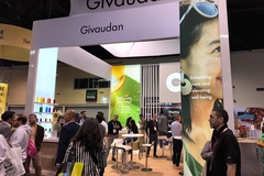 people at a trade show booth crowd of people outside Givaudan booth at a trade show