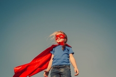 little girl poses with super person costume on
