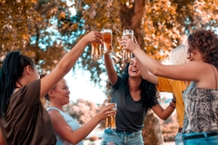 Image a group of women cheers with beer glasses