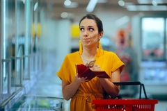 Image Shopper checking the prices feeling frustrated with her budget