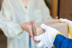 Image A person handing a box to another person