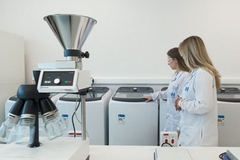 Image two scientists stand in lab coats in new facility
