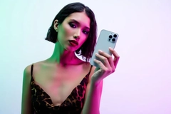Woman in colorful lighting holding cell phone