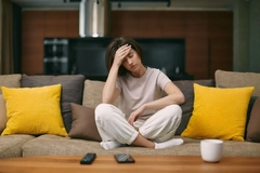 Image woman sitting on the couch being sick in long covid