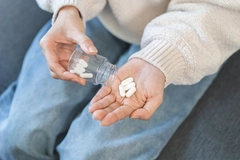 Image Person taking magnesium supplement from bottle