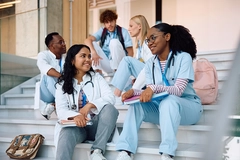 Image medical students talking while relaxing on staircase at university.