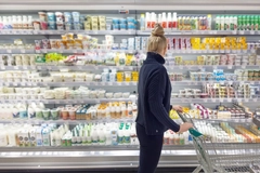 Image woman in supermarket choosing dairy products
