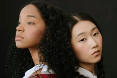 Image Two women posing in front of a dark background