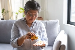 woman taking omega 3 supplement from jar