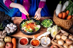 Image Korean woman is wearing a traditional hanbok, she making Kimchi