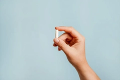 Image hand holding supplement capsule