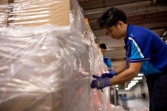 Image A person in blue gloves working on a large box