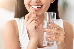Image Close Up Of Happy Smiling Asian Woman Taking Supplement Pill And Holding Glass Of Fresh Water