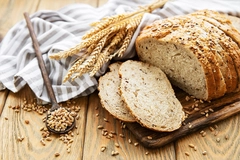 Image slices of bread next to wheat grains scattered around