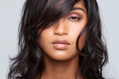 Image Indian woman with dark hair against a grey background